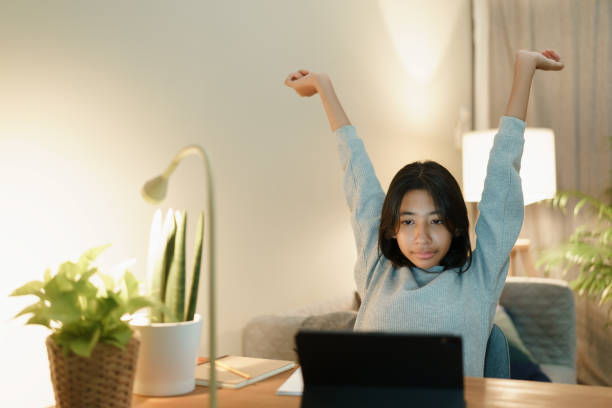 istock Asian woman raise hand while learning online with tablet at home night 1281003079