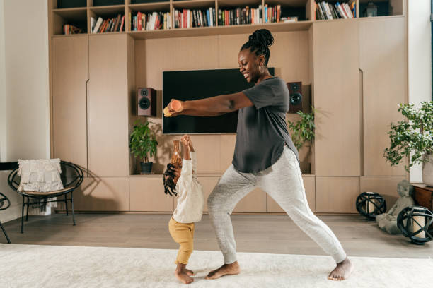 istock Young mother exercising at home with toddler around 1281006326