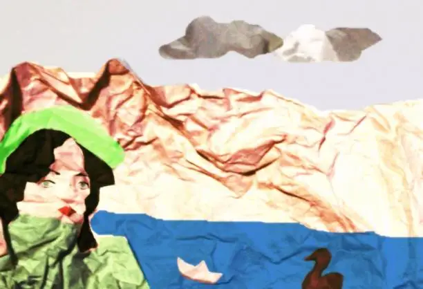 Photo of crumpled paper. Here a girl is depicted against a background of a lake and mountains. A duck floats on the lake and a paper boat floats.