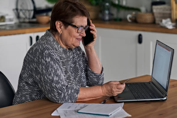 istock Happy old lady doing some shopping online using her laptop 1281008532