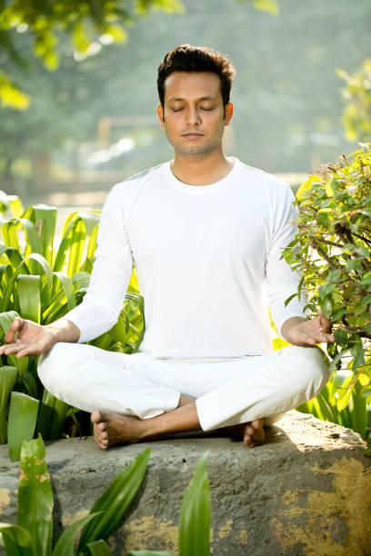 istock Man meditating in lotus position at park 1281009658