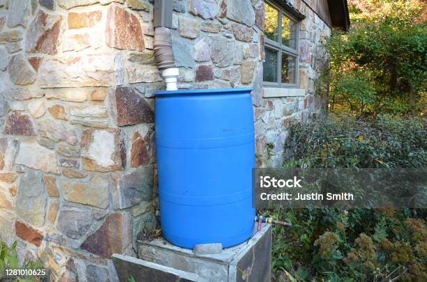 Blue Rain Barrel With Downspout And Stone Building Stock Photo - Download Image Now - Rainwater Tank, House, Barrel