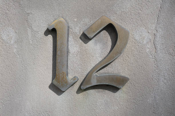 istock House number 12 on a bright white modern concretye wall 1281010719