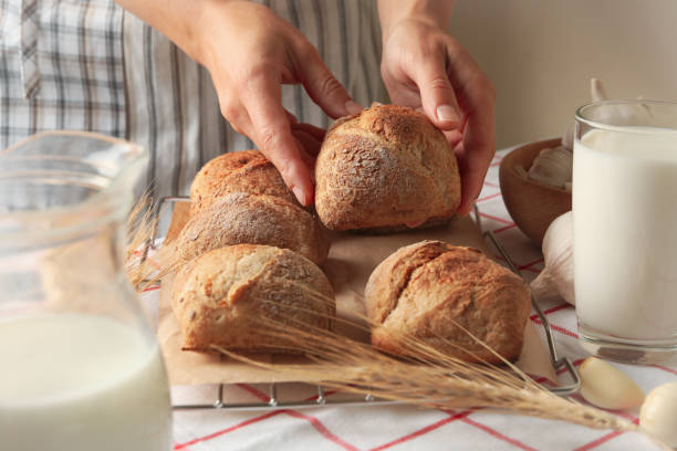 istock Woman hold fresh baked bun on table with buns 1281010777