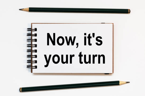 istock WHITE SPIRAL NOTEBOOK, TWO PENCILS WITH TEXT NOW IT'S YOUR TURN 1281010904
