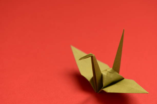istock Origami crane on red background. 1281011892