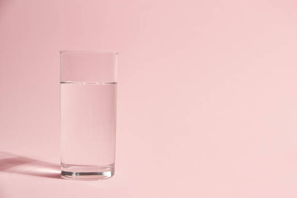 istock Glass of water on a pink background 1281012044