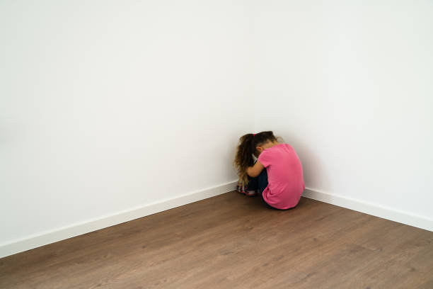 istock Afraid And Ashamed Child Kid Sitting In Corner 1281014995