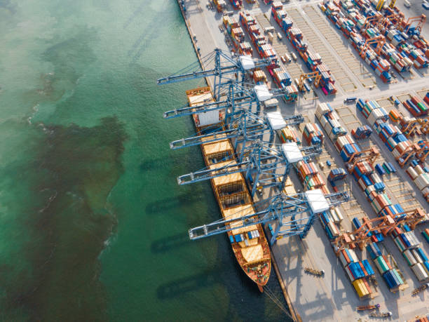 istock Container ship in import export and business logistics during business recession and , Blue ocean sea working crane, Trade Port, Shipping cargo to harbor, Aerial view from drone, International transportation, Business logistics concept 1281016005