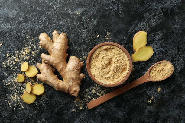 istock Ginger and bowl with ginger powder on black smoky background 1281016377