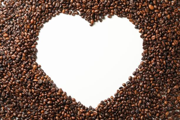 Heart made of coffee beans on white background
