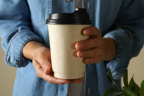 istock Woman hold blank paper cup, front view 1281016561