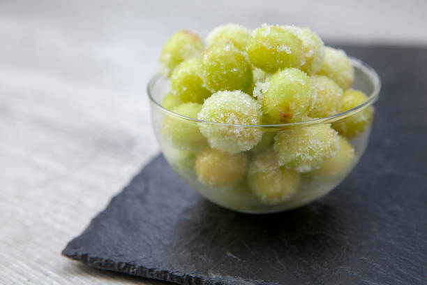 istock Sour candy grapes in a glass bowl on slate background with copy space 1281017106