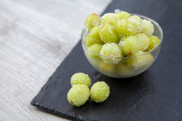 istock Sour candy grapes in a glass bowl on slate background with copy space 1281017355