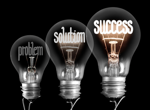 Photo of light bulbs with shining fibers in a shape of Problem, Solution and Success concept isolated on black background