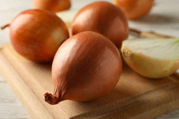istock Board with onion on wooden background, close up 1281018711