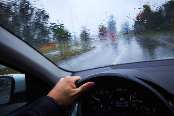 un hombre conduce un coche bajo una fuerte llovizna - slow jam fotografías e imágenes de stock
