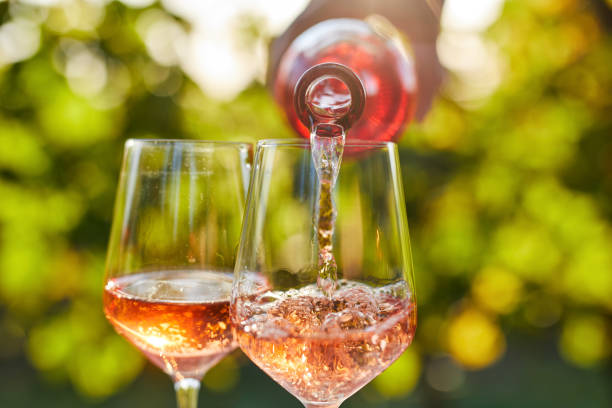 Pouring rose wine into a glass Pouring rose wine into glasses from a bottle wine tasting stock pictures, royalty-free photos & images