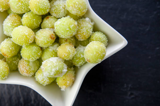 istock Sour candy grapes in star shaped bowl on slate surface viewed directly above 1281019292