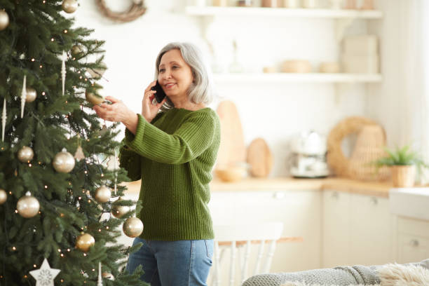 istock Woman decorating Christmas tree at home 1281020409