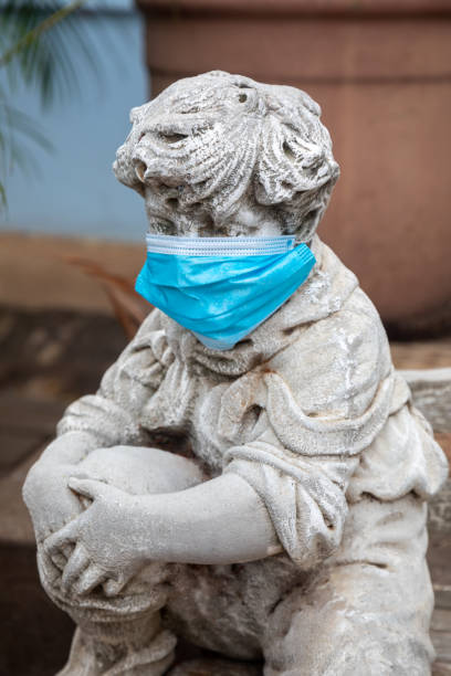 istock garden concrete statue with the face covered with a N95 surgical mask 1281020747