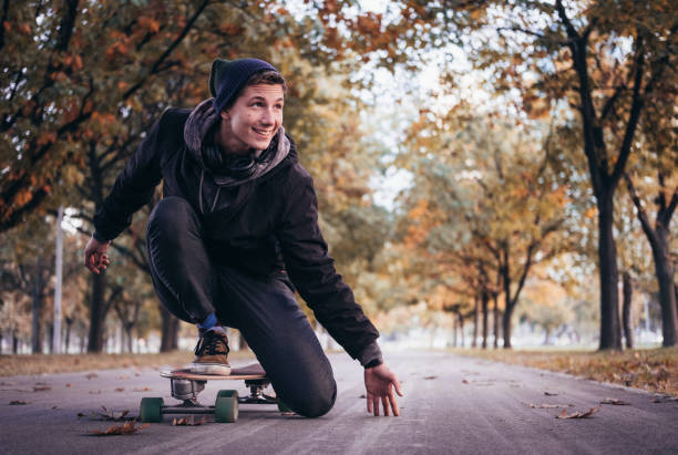 istock Young Man Rides Fast A Skateboard On The Road 1281022020