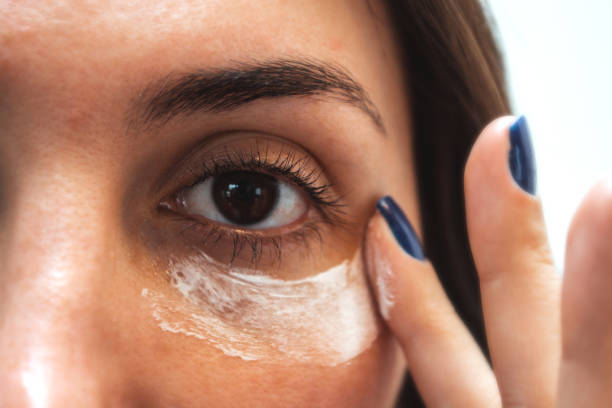 Woman applying moisturiser under her eye