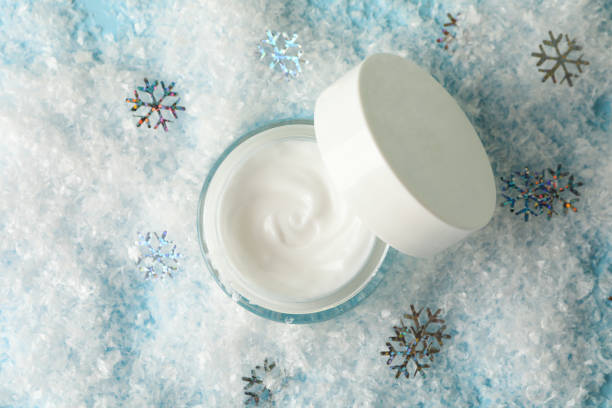 istock Jar of cosmetic cream on blue background with decorative snow 1281023045