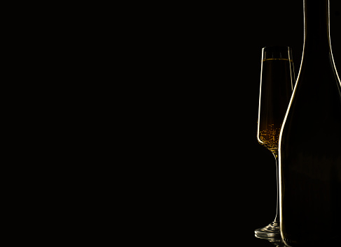 silhouette of bottle and glasses of champagne on black background