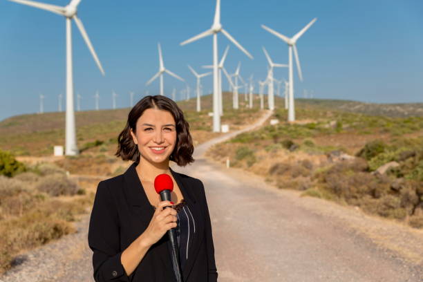 istock Female journalist presents live broadcast on wind turbines 1281032609