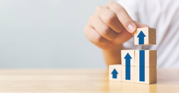 istock Hand arranging wood block stacking as step stair with arrow up. Ladder career path concept for business growth success process 1281032619
