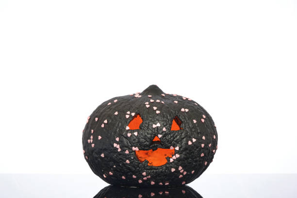 hand painted black coloured pumpkin with glitter on glass in front of a white backdrop. Halloween event
