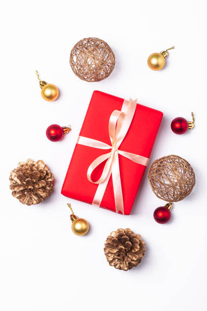 istock Christmas composition. Red gift box, pine cones, gold and red ornament decorations on white background. Winter holidays concept. Top view 1281036828