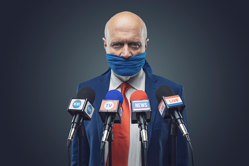 Angry politician with sealed mouth at the press conference, censorship concept
