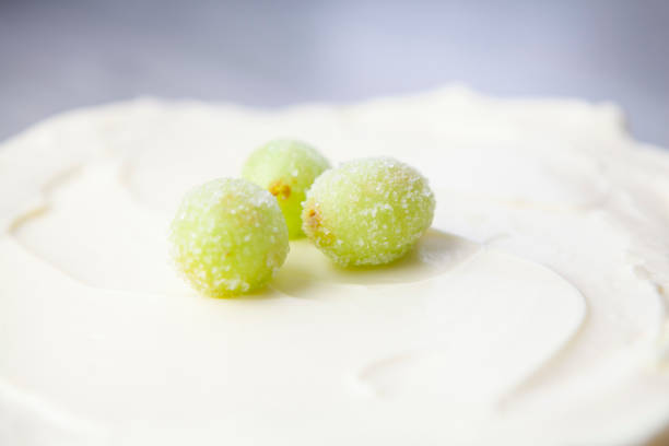 Gooseberry fruit with leaf springs on the white plate over white background. Succulent fresh ripe green organic berries Gooseberry