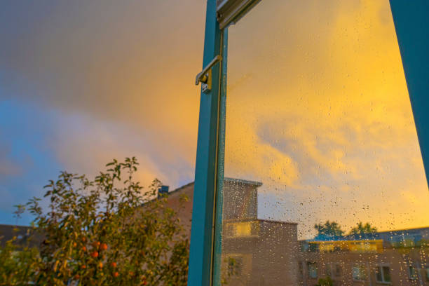 istock Grey yellow rain clouds over a windy rainy city causing raindrops on a window pane in autumn 1281042377