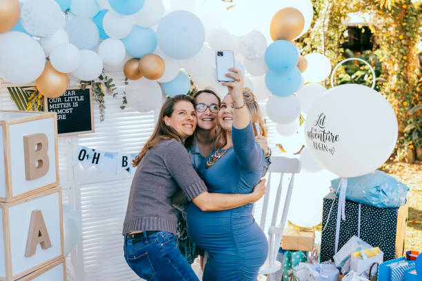 amigas femeninas haciendo selfies con una mujer embarazada en un baby shower - balloon blue red white fotografías e imágenes de stock