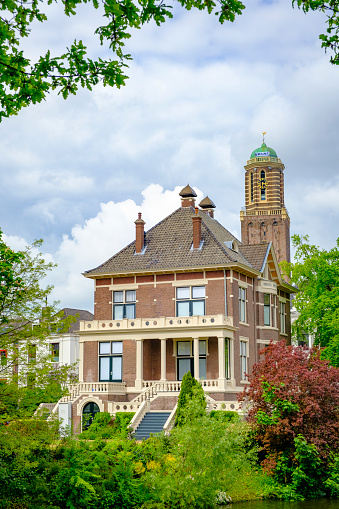 Villa next to the city canal and the Peperbus church tower in Zwolle during a springtime day
