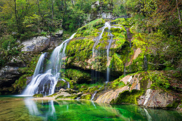 broad mystic waterfall on mossy rock stock photo