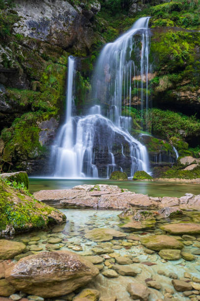 mystic waterfall on mossy rock stock photo