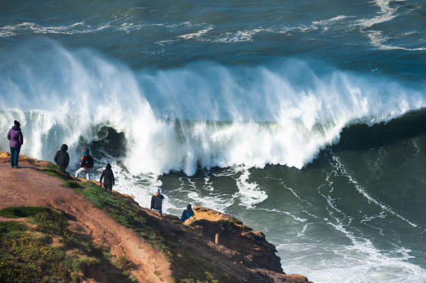 People watching big waves in Nazare, Portugal. People watching big waves in Nazare, Portugal. In this place the biggest waves in the world due to the underwater canyon nazare surf stock pictures, royalty-free photos & images