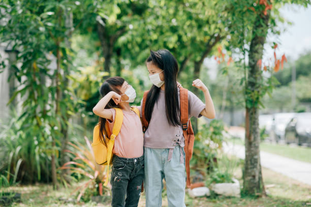 istock Two asian girls going to school with face mask. 1281046508