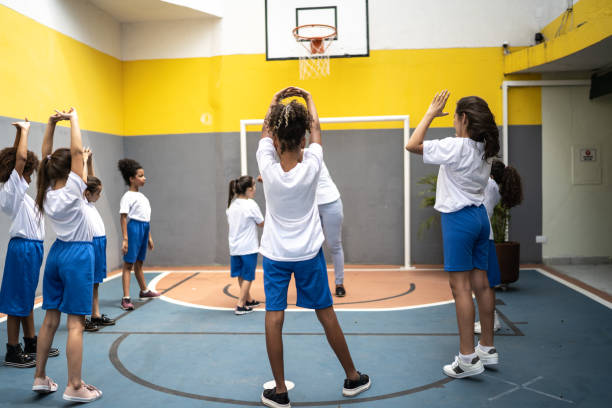 istock Physical activity teacher stretching arms with students at school 1281047122