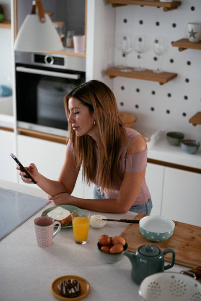istock Beautiful woman preparing breakfast and using the phone 1281047805