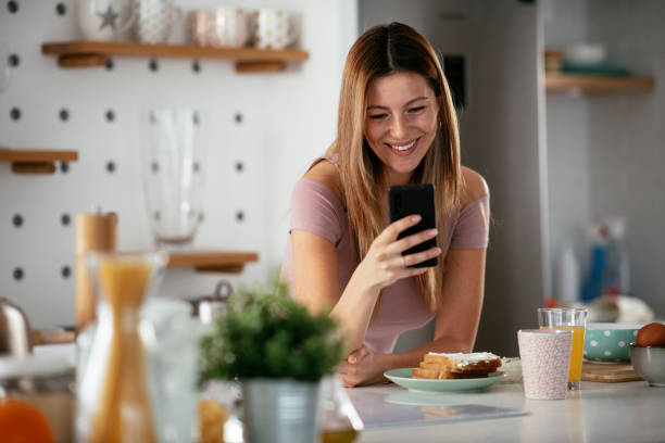 istock Beautiful woman preparing breakfast and using the phone 1281047810
