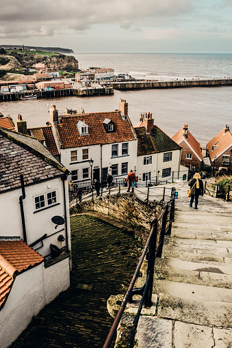 View looking down the stone steps at Whitby in the North Yorkshire region of England. The 199 steps is a local landmark leading up to the Abbey and a fine view of the town.