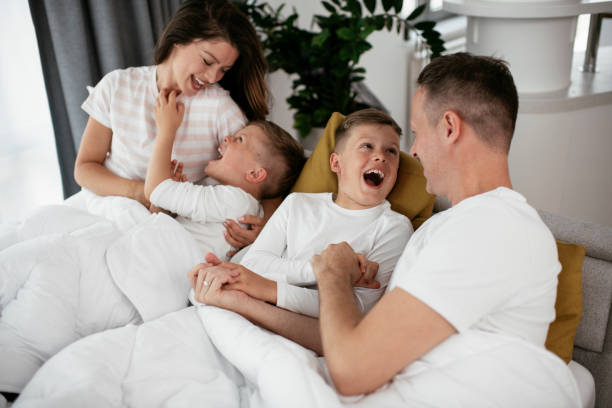 istock Happy parents with sons relaxing in bed. 1281052723
