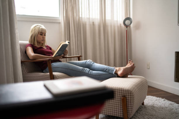 istock Woman at home sitting reading a book 1281052838
