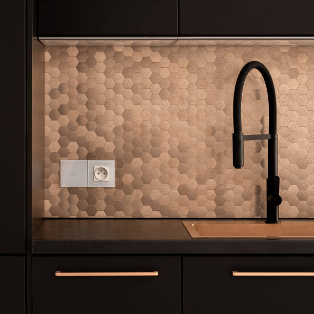 istock Black faucet in golden kitchen sink 1281054575