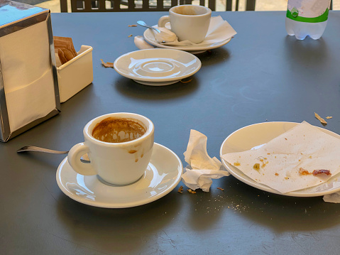 empty drunk cup of coffee and eaten cake on the table of the cafe close-up. Coffee break concept.
